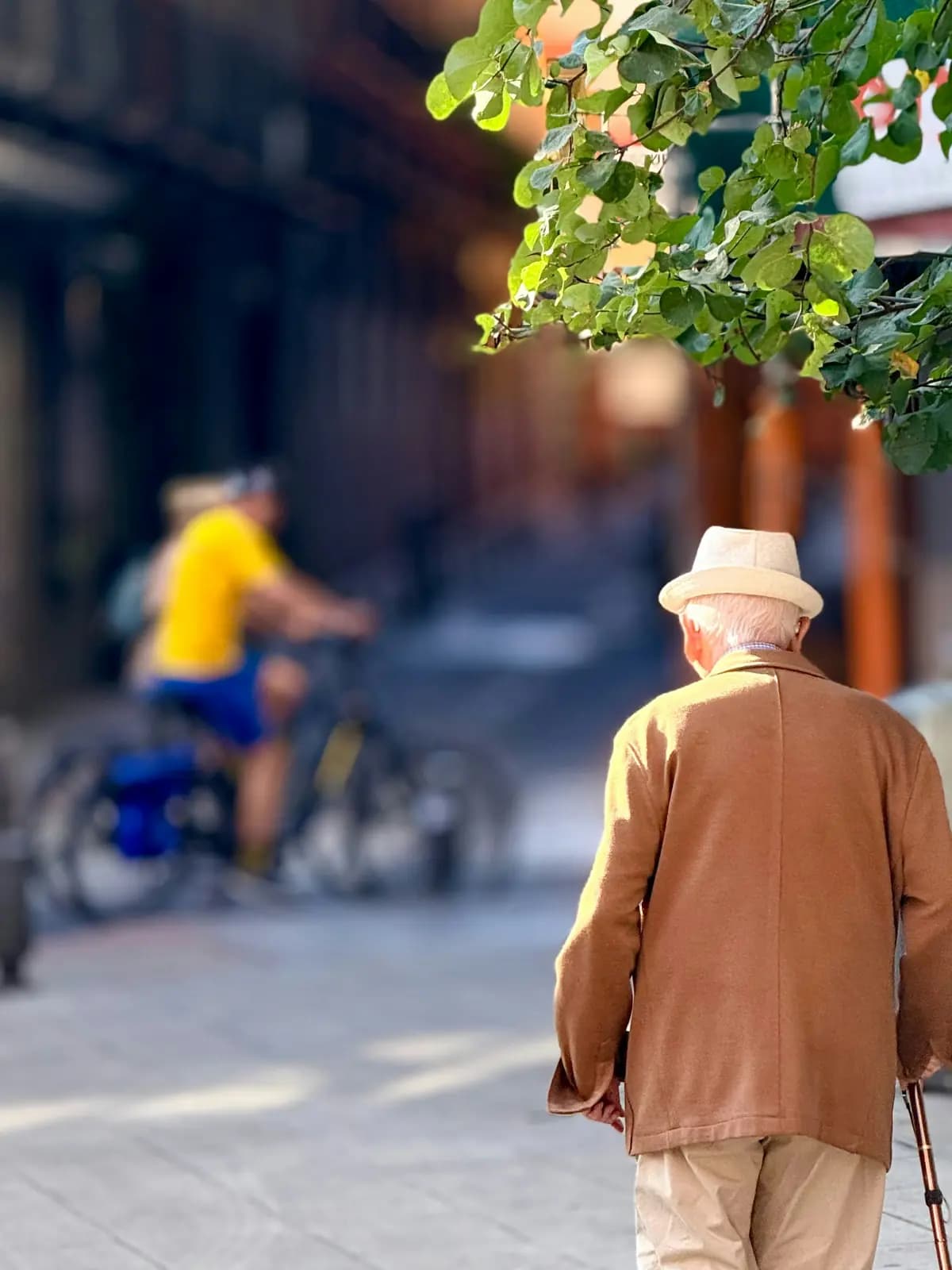 Un hombre mayor con bastón caminando por la calle